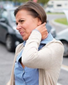 A woman holding her neck in pain